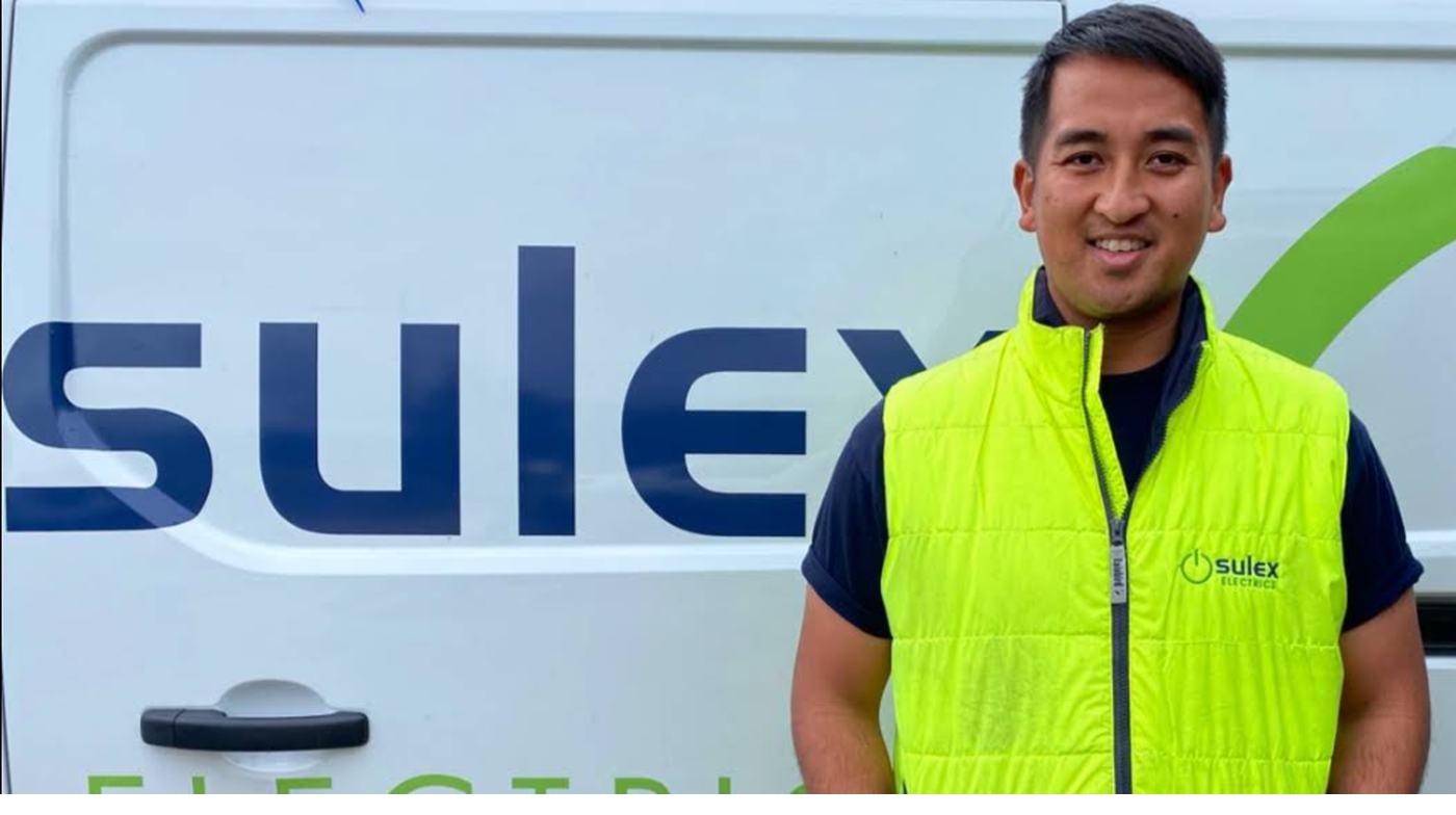 Alex, qualified electrician and owner of Sulex Electrics, standing beside the company van